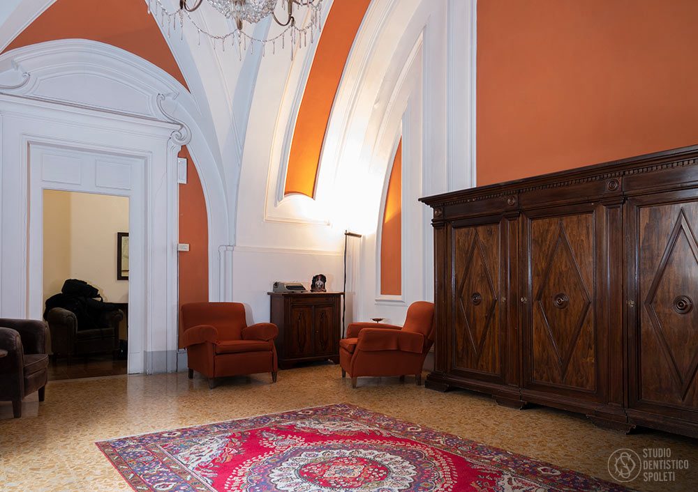 La sala d’aspetto, con i soffitti a volta dipinti, il tappeto e la boiserie